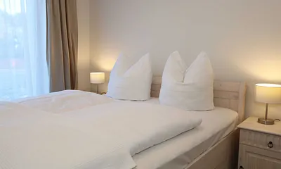 Schlafzimmer  im Landhausstil mit großem Doppelbett (1,60 m x 2,00 m), 5-Zonen-Federkern-Matratzen, verstellbare Lattenroste, Nackenkissen, Nachttischablagen und geräumigen Einbauschrank