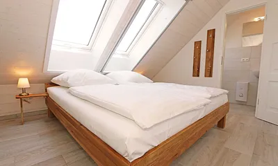 Schlafzimmer mit Doppelbett (1,80 m x 2,00 m), Nachttischablagen, Kleiderschrank und En Suite Badezimmer mit WC, Waschplatz, Fön und Dusche