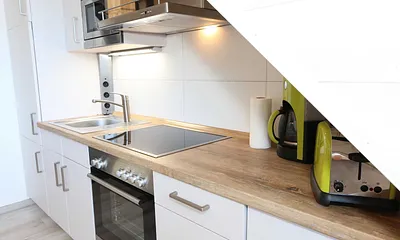 Küchenzeile mit Geschirrspüler, Backofen, 4 Zonen-Cerankochfeld, Kühlschrank mit Gefrierkombination, Kaffeemaschine, Mikrowelle, Toaster, Wasserkocher und vielen Küchenhelfern