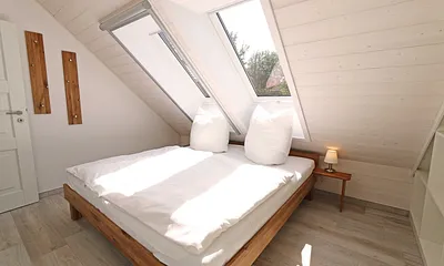 Schlafzimmer mit Doppelbett (1,80 m x 2,00 m), Nachttischablagen, Kleiderschrank und En Suite Badezimmer mit WC, Waschplatz, Fön und Dusche