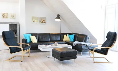 Wohnzimmer mit großem Ledersofa, Leselampe, 2 Relax-Sessel, Lowboard mit Smart-TV, Blu-Ray-Player und Radio mit CD-Player