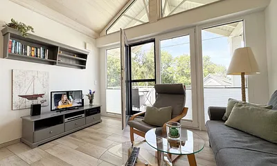 gemütliches Wohnzimmer mit Couch und Smart-TV