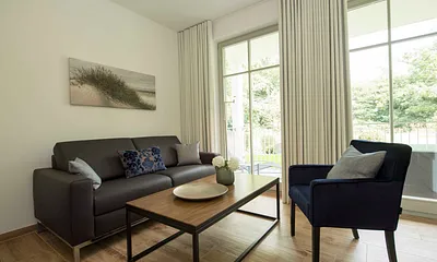 Wohnzimmer mit gemütlicher Couch, Flachbild-LED-TV und Blu-Ray-Player