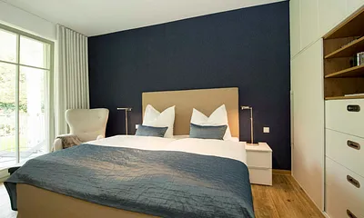 Schlafzimmer mit bequemen Doppelbett mit 4 Gang-Bonell-Federkern Matratzen (1,80 m x 2,00 m), Kleiderschrank, Nachttischablagen, Safe, Wecker und Verdunklungsmöglichkeit