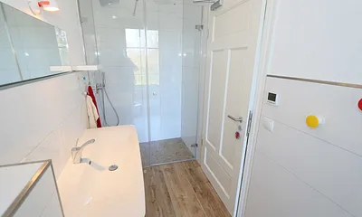 kleines Bad mit bodengleicher Dusche, WC und Waschtisch