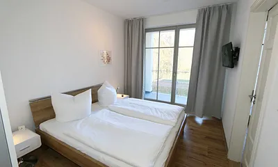 Schlafzimmer (en-suite) mit bequemen Komfort- Doppelbett (1,80 m x 2,00 m), hochwertigen Matratzen, verstellbaren Lattenrosten, Kleiderschrank, Nachttische und Wecker