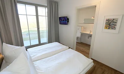 Schlafzimmer (en-suite) mit bequemen Komfort- Doppelbett (1,80 m x 2,00 m), hochwertigen Matratzen, verstellbaren Lattenrosten, Kleiderschrank, Nachttische und Wecker