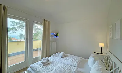 Schlafzimmer mit Doppelbett und Blick zur Ostsee