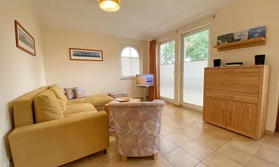 Wohnbereich mit Eckcouch, Couchtisch, Sessel, LCD-TV und ein Radio mit CD-Player