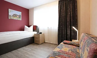 Schlafzimmer mit Einzelboxspringbett (100 x 200 cm) und einer Schlafcouch (140 x 195 cm),Nachtschränke,dimmbaren Nachttischlampen,Radiowecker,2- türiger Kleiderschrank,32 Zoll Flachbild mit Smart-TV