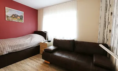 Schlafzimmer mit Einzelboxspringbett (100 x 200 cm) und einer Schlafcouch (140 x 195 cm),Nachtschränke,dimmbaren Nachttischlampen,Radiowecker,2- türiger Kleiderschrank,32 Zoll Flachbild mit Smart-TV