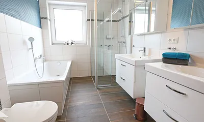 Tageslichtbad mit bodengleicher Echtglasdusche, Badewanne, 2 Waschtische, Kosmetikspiegel, Spiegelschrank, WC, Handtuchtrockner, Haarfön