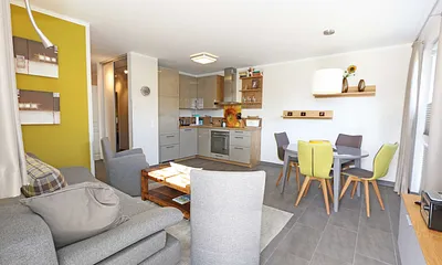 offener Wohnbereich mit gemütlicher Couch, Couchtisch, 2 Leselampen (integriert in den Wandleuchten bei der Couch), Smart-TV, Blu-Ray Player sowie eine Mini-Stereo-Anlage von Sonoro 