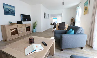 offener Wohnbereich mit gemütlicher Sitzecke, Couchtisch, Sessel, Leselampe, Smart-TV mit CD-Player, DAB Radio und Blu-Ray-Player