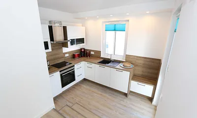 Küchenzeile mit Ceranfeld, Backofen, Geschirrspüler, Mikrowelle, Kühlschrank mit Gefrierfach, Kaffeemaschine, Wasserkocher, Toaster und diversen Küchenutensilien