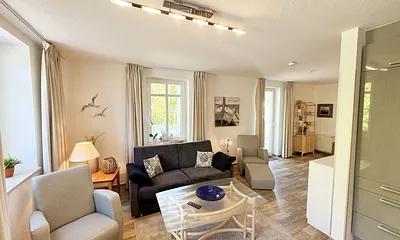 Wohnbereich mit Couchecke (Ausziehfunktion, Aufbettung 3./4. Person, 1,80 m x 2,00 m), Couchtisch, Leselampe und Sideboard mit Smart-TV sowie Radio + CD-Player