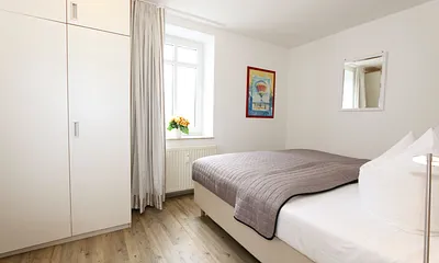 Schlafzimmer mit Doppelbett (2 x 0,90 m x 1,80 m), Nachtischkonsolen und geräumiger Kleiderschrank