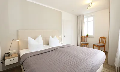 Schlafzimmer mit Doppelbett (2 x 0,90 m x 1,80 m), Nachtischkonsolen und geräumiger Kleiderschrank