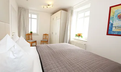 Schlafzimmer mit Doppelbett (2 x 0,90 m x 1,80 m), Nachtischkonsolen und geräumiger Kleiderschrank