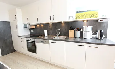 Küchenzeile mit Mikrowelle und diversen  Küchenutensilien