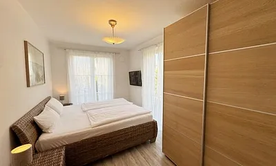 Schlafzimmer mit Doppelbett (2x 0,90 m x 2,00 m) in Komforthöhe (60cm) und zwei 7-Zonenkaltschaummatratzen,Nachttischablagen,Kleiderschrank,Wandspiegel und 40 Zoll LED - Flachbild TV