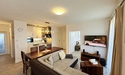 Wohnbereich mit Massivholzmöbeln, gemütliche Eckcouch, 50 Zoll LED-Flachbildschirm, Blu-ray-Player, Stereoanlage, Bücherauswahl, Gesellschaftsspiele und textiles Kinderspielzeug