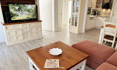 Wohnbereich mit Massivholzmöbeln mit großer Couch, Couchtisch, Leselampe, 4K UHD LED Smart-TV, Soundbar, CD/DVD/Blu-Ray-Player