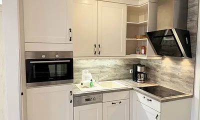 Küchenzeile mit Kühlschrank und Gefrierfach, Backofen, Geschirrspüler, Mikrowelle, Cerankochfeld, Kaffeemaschine, Thermoskanne, Wasserkocher, Teekanne, Toaster sowie diverse Küchenutensilien