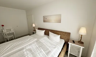 Schlafzimmer mit großem Doppelbett (2x 1,00 m x 2,00 m) in Komforthöhe, verstellbare Lattenroste, Nachttische, Kleiderschrank, Sekretär und Smart-TV mit Sat-Fernsehen