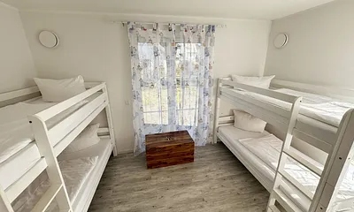 Schlafzimmer mit zwei Etagenbetten, Kleiderschrank, Schatzkiste mit Spielsachen, 2 Kinderreisebetten (mit Matratzen), Wickelkommode