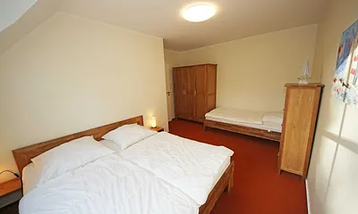Schlafzimmer mit Doppelbett (2x 0,90 m x 2,00 m), verstellbare Lattenroste, Nachtischablagen, Kleiderschrank und zusätzlichem Einzelbett (0,90 m x 2,00 m) sowie Insektenschutzgitter