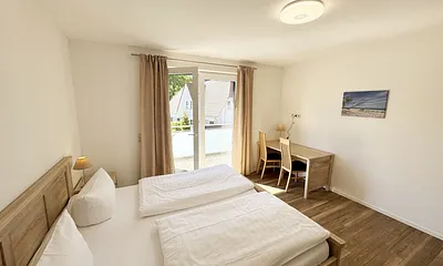 Schlafzimmer mit Doppelbett und Schreibtisch