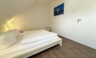 Schlafzimmer mit Doppelbett (1,60 m x 2,00 m), geräumigen Kleiderschrank und Wecker