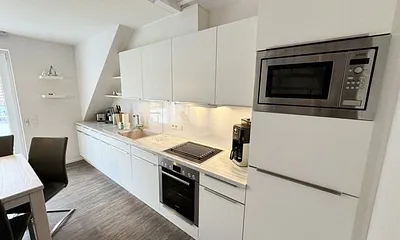 Einbauküche mit Markengeräten wie Geschirrspüler, Induktionsfeld mit Backofen, Kühlschrank mit Gefrierfach, Mikrowelle, Kaffeemaschine, Toaster, Wassserkocher sowie kleine Küchenhelfer