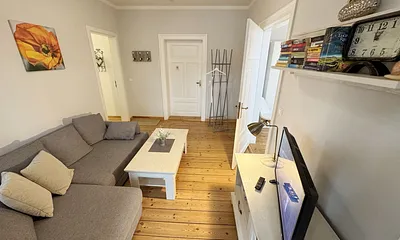 Wohnzimmer mit gemütlicher Couch und Flachbild-TV