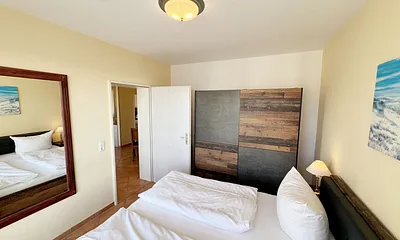 Schlafzimmer mit Doppelbett und Kleiderschrank