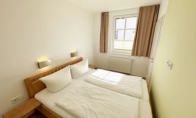 Schlafzimmer mit Doppelbett mit Nachttischkonsolen