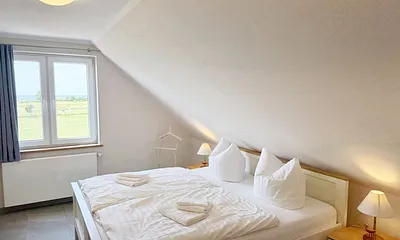Schlafzimmer mit Doppelbett und Nachttischkonsolen