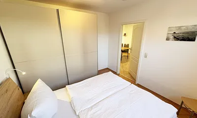Schlafzimmer mit Doppelbett und Schwebetüren-Kleiderschrank