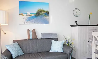 Wohnraum mit gemütlicher Couch, Leselampe, Smart-TV, Blu-Ray-Player und einer Stereoanlage mit DAB-Radio