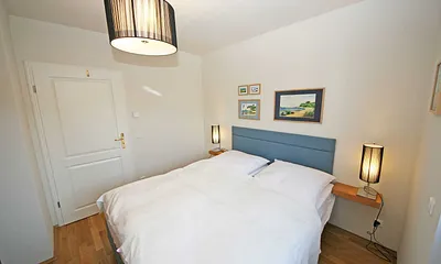 Schlafzimmer mit Doppelbett (1,60 m x 2,00 m), Nachtischkonsolen und Kleiderschrank