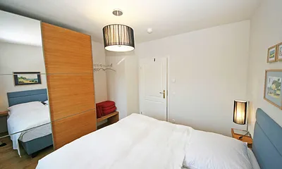 Schlafzimmer mit Doppelbett (1,60 m x 2,00 m), Nachtischkonsolen und Kleiderschrank