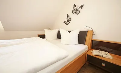 Schlafzimmer mit Doppelbett mit Tempur-Matratzen (2 x 0,90 m x 2,00 m), 2 Nachttischablagen und Panorama - Spiegelschrank