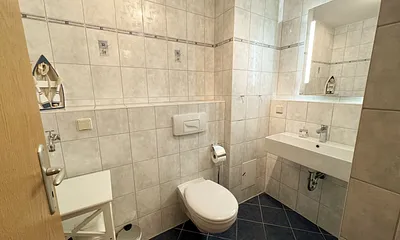 Badezimmer mit Dusche, Waschtisch, Kosmetikspiegel, Fön und WC