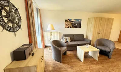 Wohnbereich mit Schlafsofa  (1,50m x 1,90m), Couchtisch und Flachbild – TV