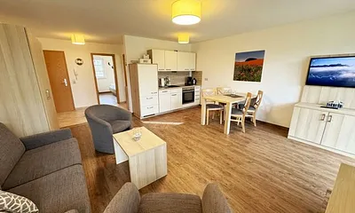 Wohnbereich mit Schlafsofa  (1,50m x 1,90m), Couchtisch und Flachbild – TV