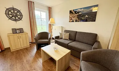 Wohnbereich mit Schlafsofa  (1,50m x 1,90m), Couchtisch und Flachbild – TV