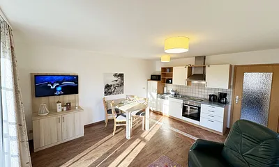 Wohnbereich mit Schlafsofa (Aufbettungsmöglichkeit für die 3./4. Person, 1,50m x 1,90m), Couchtisch und Flachbild – TV