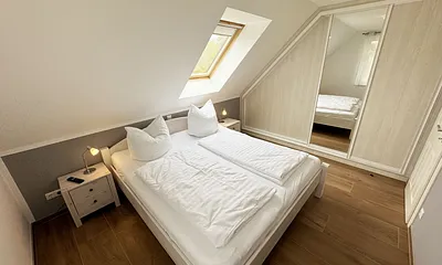 Schlafzimmer mit Doppelbett (1,80 m x 2,00 m), Kleiderschrank und Komode