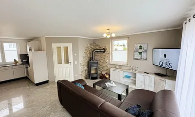 Wohnzimmer mit gemütlicher Couch, Smart-TV, DAB Radio, Blu-Ray-Player sowie ein direkter Zugang über die Schiebetür auf die Terrasse